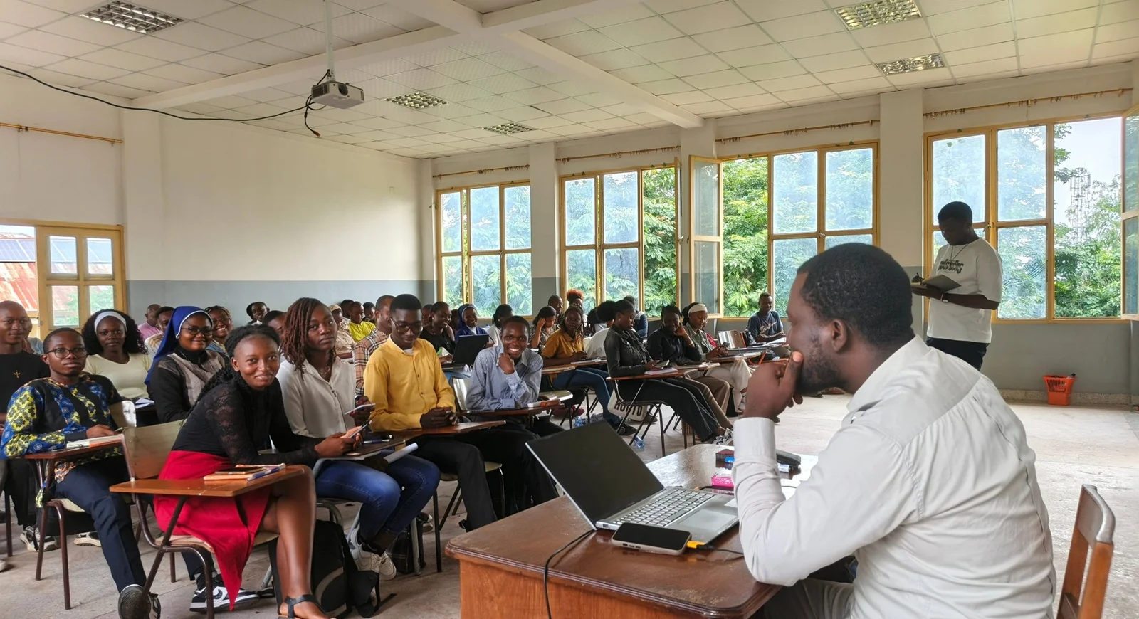 Trésor Dimandja with a group of learners in a classroom.