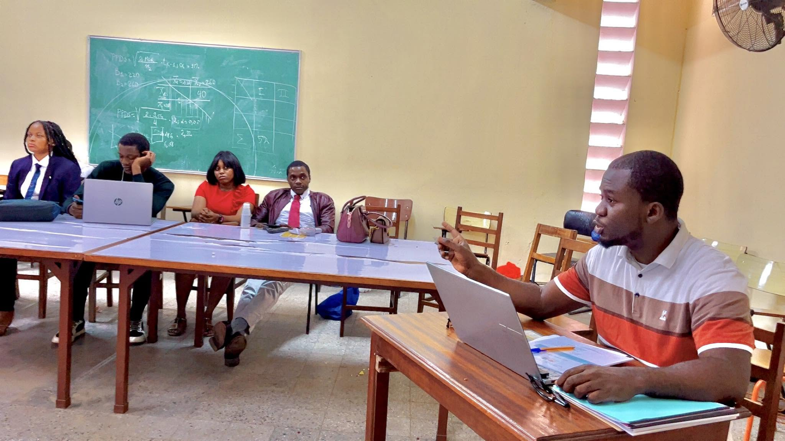 Trésor Dimandja leading a session with participants around a table.